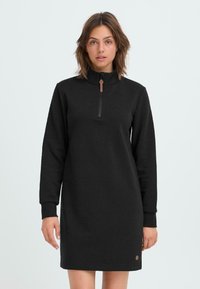 Zwarte sweatshirt jurk met een hoge kraag, voorzien van een ritssluiting aan de voorkant en lange mouwen, gemaakt van zachte stof, met een logodetail aan de zoom.