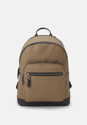 Brązowy plecak Michael Kors z monogramem, przednią kieszenią na zamek, czarną podstawą i górnym uchwytem na białym tle.