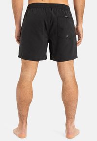 Schwarze Badehose mit elastischem Bund, ausgestattet mit einer hinteren aufgesetzten Tasche und verstärkten Nähten. Glattes Material mit leichtem Tragegefühl.