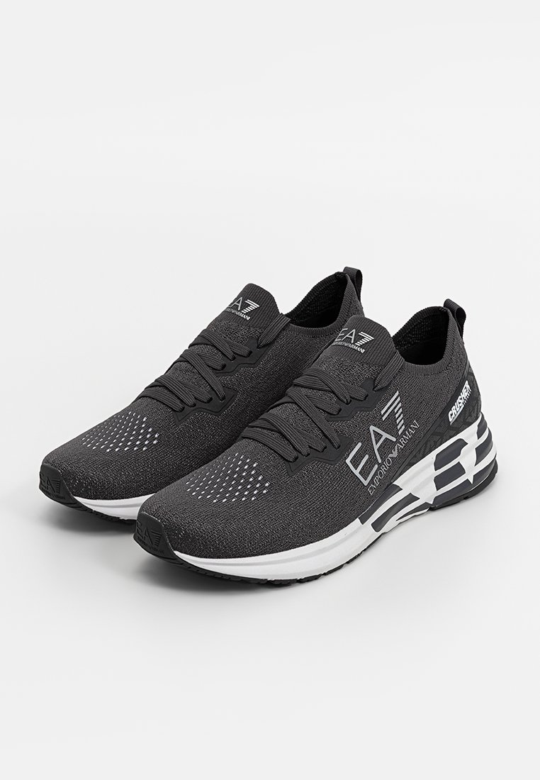 Schwarz-weiße EA7 Emporio Armani Strick-Sneaker mit Schnürsenkeln und Marken-Sohle auf einem schlichten hellen Hintergrund.