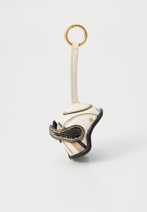 Leather keychain holder in cream with black and gold wing design, accent strips, and gold ring for attachment. Textured surface detailing.