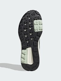 Semelle en caoutchouc de basket avec un motif texturé et des crampons profonds, accentuée de sections vert clair et d'une base noire pour une meilleure adhérence.
