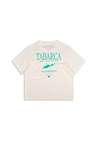 Camiseta corta color beige claro con texto turquesa y un gráfico de un mapa. El texto incluye "TABARCA" y referencias a localidades en el Mediterráneo.