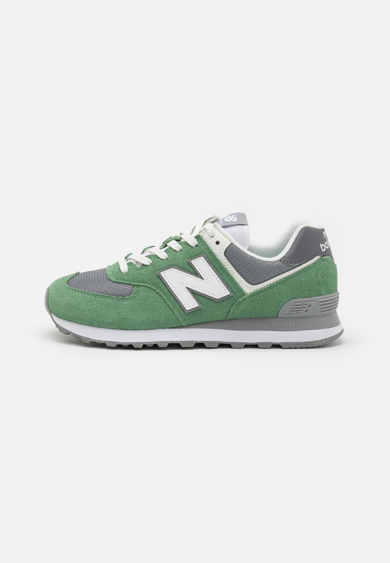 Baskets en daim vert et en maille grise avec des accents blancs et gris, comportant un col rembourré, une semelle extérieure durable et un logo "N" bien visible.