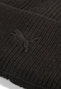 Sort strikket hue med ribbet tekstur, der har et sort Puma-logo broderet på forsiden. Fremstillet af blødt, varmt materiale.