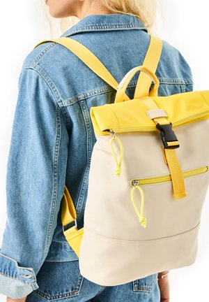 Beige Rucksack mit einem gelben Roll-Top, verstellbaren Trägern, einer Frontreißverschlusstasche und gelben Akzenten an Beschlägen und Details.