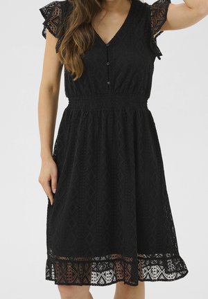 Schwarzes Spitzenkleid mit V-Ausschnitt, kurzen gerafften Ärmeln, Knopfleiste vorne, geraffter Taille und feinen Diamantmustern auf dem Stoff.