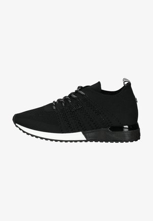 Schwarze Sportschuhe mit einem gestrickten Obermaterial, strukturiertem Design, weißem Sohlenakzent und schwarzen Schnürsenkeln. Sie verfügen über eine halbtransparente Ferse.