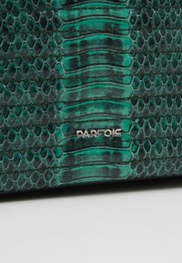 Grøn slangeskinnemateriale med en tekstureret overflade og syede linjer. Sølv "PARFOIS" logoet er synligt på forsiden.