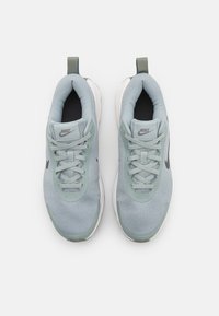 Baskets Nike bleu clair avec une tige en maille, fermeture à lacets et accents gris. Présente un bout arrondi et une semelle blanche rembourrée.