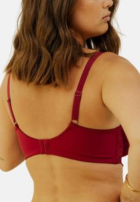 Soutien-gorge bourgogne avec bretelles ajustables, doté de détails en dentelle et d'une fermeture à crochets à l'arrière. Texture de tissu lisse.