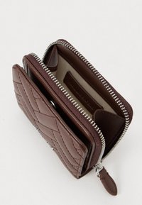 Brązowy skórzany portfel z pikowanym wzorem, zamknięcie na zamek błyskawiczny oraz wewnętrznymi przegródkami na karty. Akcenty w srebrnym kolorze na zamku i elementach metalowych.
