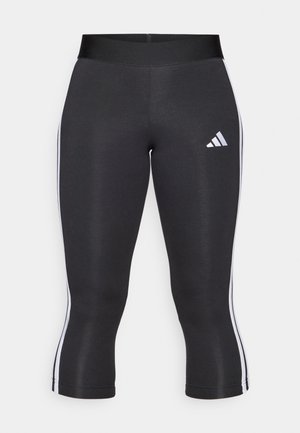 Crne capri tajice sa širokim pojasom, sa bijelim bočnim prugama i bijelim Adidas logom na lijevom bedrima. Glatka tekstura.