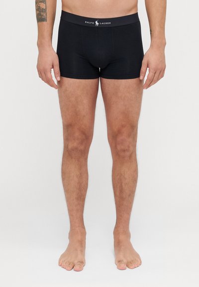 Boxers noirs en coton avec une coupe ajustée, dotés d'une taille avec logo. Texture lisse et sans motifs visibles.
