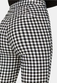 Zwart-witte gingham patroon leggings met een hoge taille, met een gladde textuur en achterzakken.