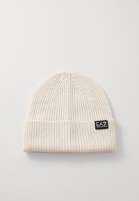 Kremowa dziana czapka z prążkowanym wzorem, z zagiętym mankietem i metką z logo EA7 Emporio Armani po boku.