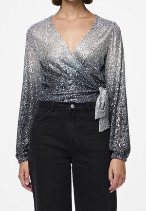 Langærmet sølvglimmer-wrap-top med sidesløjfe, kombineret med højtaljede sorte jeans, vist fra skuldre til hofter.