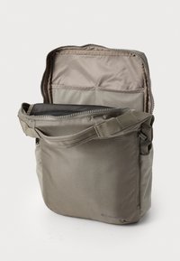 Gray fabric messenger bag with a zippered opening, interior zip pocket, adjustable strap, and logo detail on the bottom corner.
