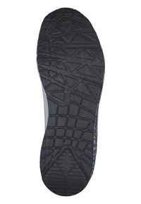 Suela de zapato de goma negra con un patrón texturizado de triángulos y surcos; diseño lateral multicolor visible en el borde.
