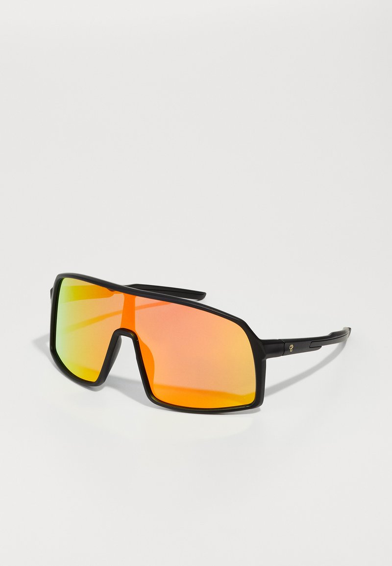 Ochelari de soare cu o ramă neagră groasă, lentile mari dreptunghiulare cu un gradient de la verde la portocaliu și teme subțiri din metal.