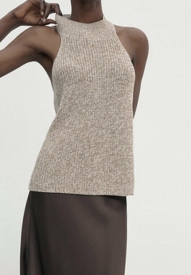 Beige ärmelloses Strickoberteil mit hohem Halsauschnitt. Gewebte Textur mit lässiger Passform. Kombiniert mit einem glatten dunkelbraunen Rock.
