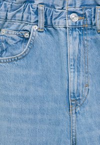 Jeans de mezclilla azul claro con una cinturilla estilo fruncido, que cuentan con un bolsillo frontal y detalles de costura visibles en un tono más claro.