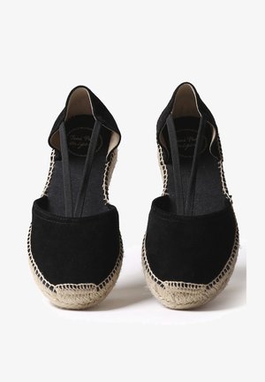 Černé espadrilky vyrobené z semiše s jutovou podrážkou. Obsahují elastické vsadky a kontrastní šití podél okraje. Ploché provedení.