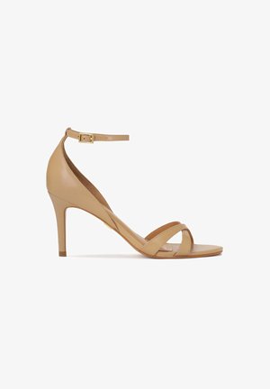 Beige leren sandalen met hak, een enkelbandje, open teen en een kruislings ontwerp aan de voorkant. Heeft een slanke hak en een gladde afwerking.