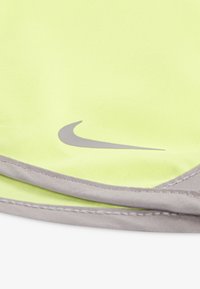 Nike sports visor in vibrant yellow fabric, featuring a sleek gray logo and a soft gray trim along the edge. Smooth texture, foldable design.