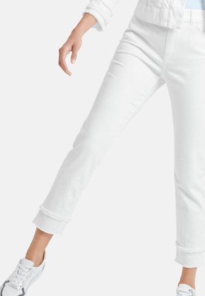 Białe spodnie z denimu o prostych nogawkach, wywiniętym mankiecie i lekkiej fakturze, zestawione z białymi butami sportowymi. Prosty, uniwersalny design.