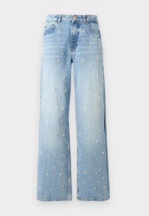 Light blue wide-leg jeans with pearl and flower-shaped bead embellishments scattered across the fabric, front button, and pockets visible.