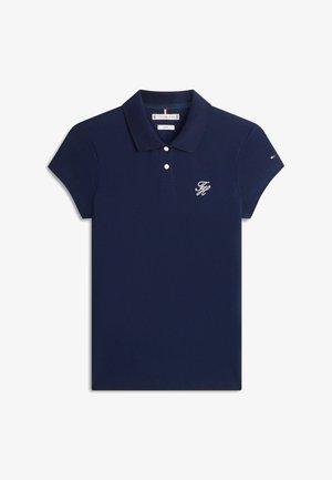 Tamsiai mėlynas trumpomis rankovėmis polo marškinėlis su dviem baltais mygtukais, mažas baltas siuvinėtas logotipas kairėje krūtinės pusėje ir mažytis vėliavos detalė kairėje rankovėje.