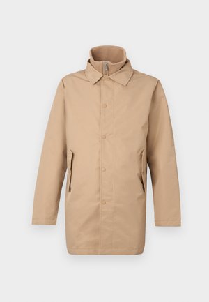 Casaco bege, de comprimento médio, com uma gola alta, fechos de botão e zíper e dois bolsos laterais. Tecido liso sem padrões ou adornos.