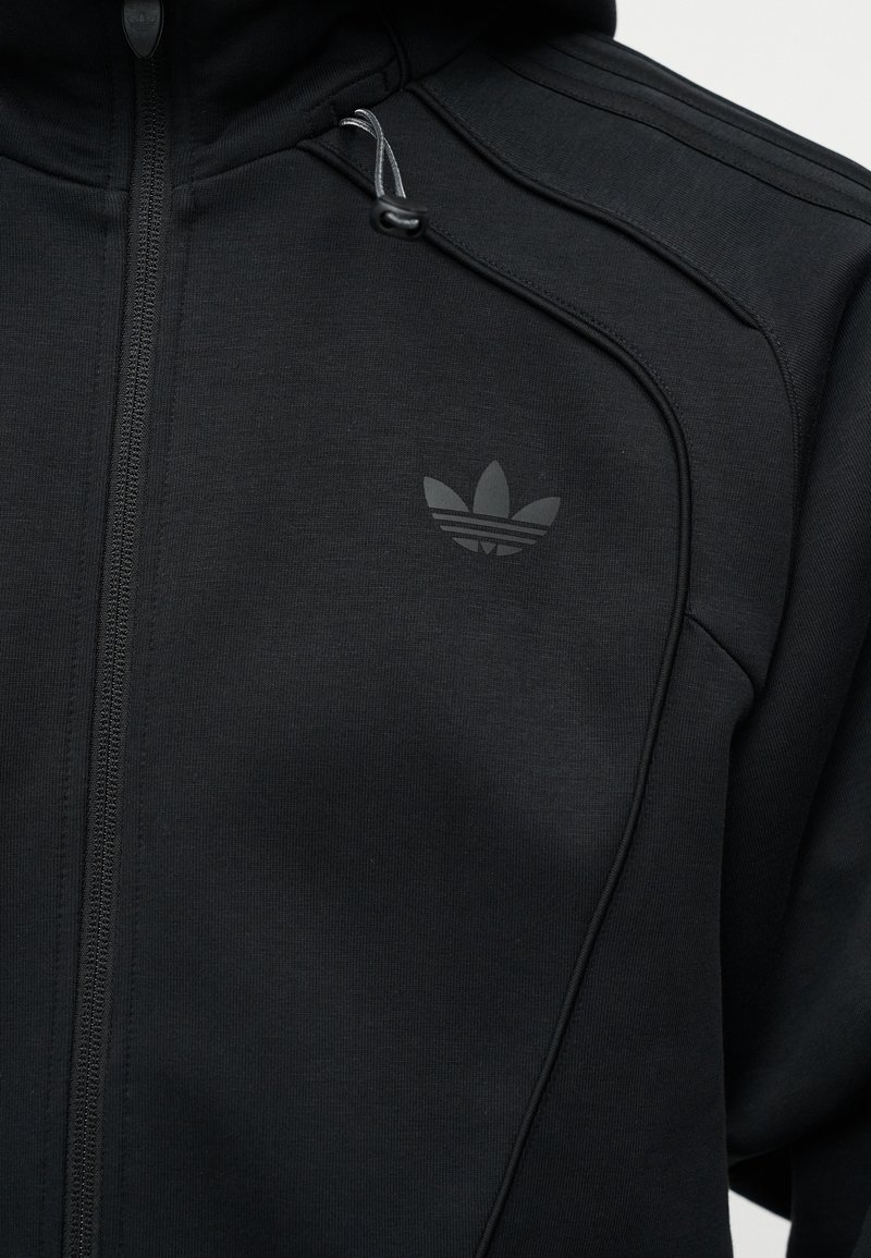 Zwarte hoodie met ritssluiting, voorzien van het Adidas trefoil-logo op de linkerborst en capuchonkoordjes met trekker.