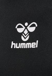 Weißes, stilisiertes Bienen-Logo mit geometrischen Formen über dem Wort „hummel“ auf schwarzem, strukturiertem Stoffhintergrund.