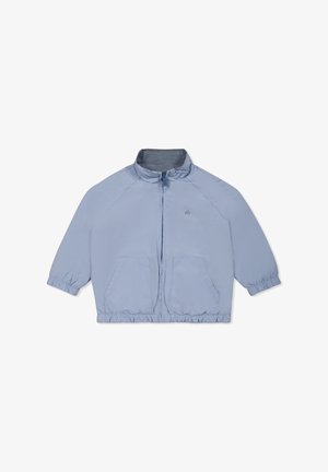 Giacca leggera di colore azzurro, con colletto alto, chiusura con zip, polsini elasticizzati e due tasche frontali. Materiale liscio con una leggera lucentezza.