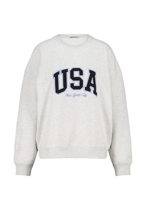 Lichtgrijze sweatshirt met een ronde halslijn en verlaagde schouders. Bevat vetgedrukte zwarte tekst "USA" en daaronder "New York City" in lichtblauw gedrukt.