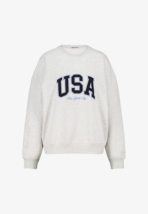 Sweatshirt gris clair avec un col rond et des épaules déchues. Présente un texte noir en gras "USA" et "New York City" imprimé en dessous en bleu clair.