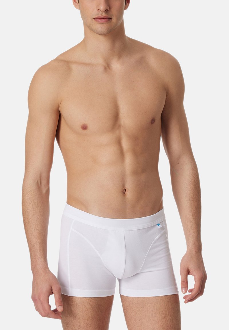 Weiße Baumwoll-Boxershorts mit einem weichen Bund, figurbetontem Design und einer konturierten Tasche. Sanfte Textur, minimalistischer Stil.