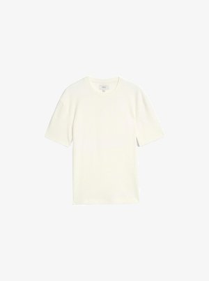 Tričko s krátkým rukávem a kulatým výstřihem v barvě slonové kosti, se žebrovanou strukturou a volným střihem, vyrobené z měkké, prodyšné látky.