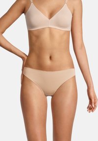 Reggiseno beige senza cuciture e bikini coordinato realizzati in morbido tessuto elasticizzato. Il reggiseno ha spalline regolabili e una forma triangolare classica.