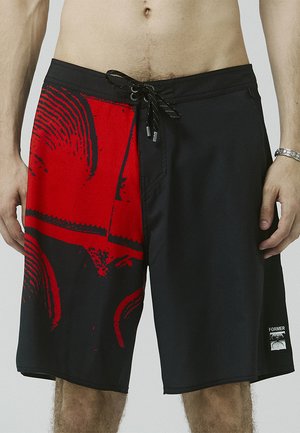 Board shorts with a black base, featuring a large red graphic print. Includes a drawstring waist and a side pocket with logo detail.