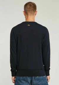 Maglione pullover blu scuro, texture a maglia, collo a giro, maniche lunghe, polsini e orlo a coste, presenta una piccola etichetta del marchio sulla parte posteriore.