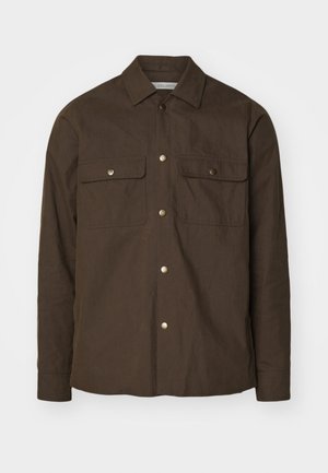 Bruine katoenen shirtjack met een puntkraag, knoopsluiting aan de voorkant en twee borstzakken. Voorzien van gouden drukknoopknopen en lange mouwen.