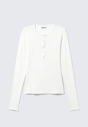 White long-sleeve shirt with a round neckline, front button placket, and a smooth texture. Simple design and relaxed fit.