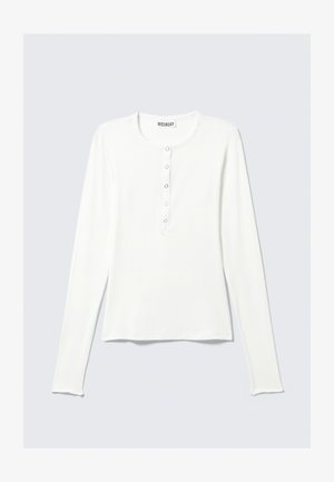 Valge pikkade varrukatega särk ümarate krae ja ees nupuga, sujuva tekstuuriga. Lihtne disain ja ruumikas istuvus.