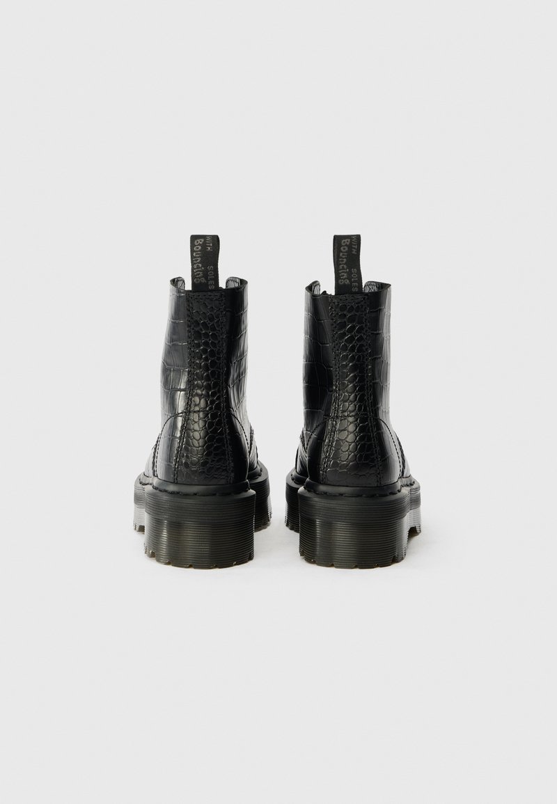 Pair of black crocodile-patterned combat boots with thick soles and pull tabs at the back, photographed against a white background.