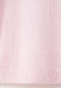 Mjukt rosa stickad tyg med ribbat avslut, som visar upp fina, jämna stygn och en slät yta.