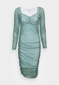 Robe longue verte en voile à manches longues avec un motif floral blanc, design froncé et décolleté carré. Le tissu semble léger et texturé.