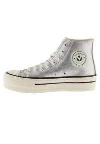 Baskets montantes argentées avec surface texturée, lacets blancs, semelle en caoutchouc et logo rond "Victoria Since 1915" sur le côté.